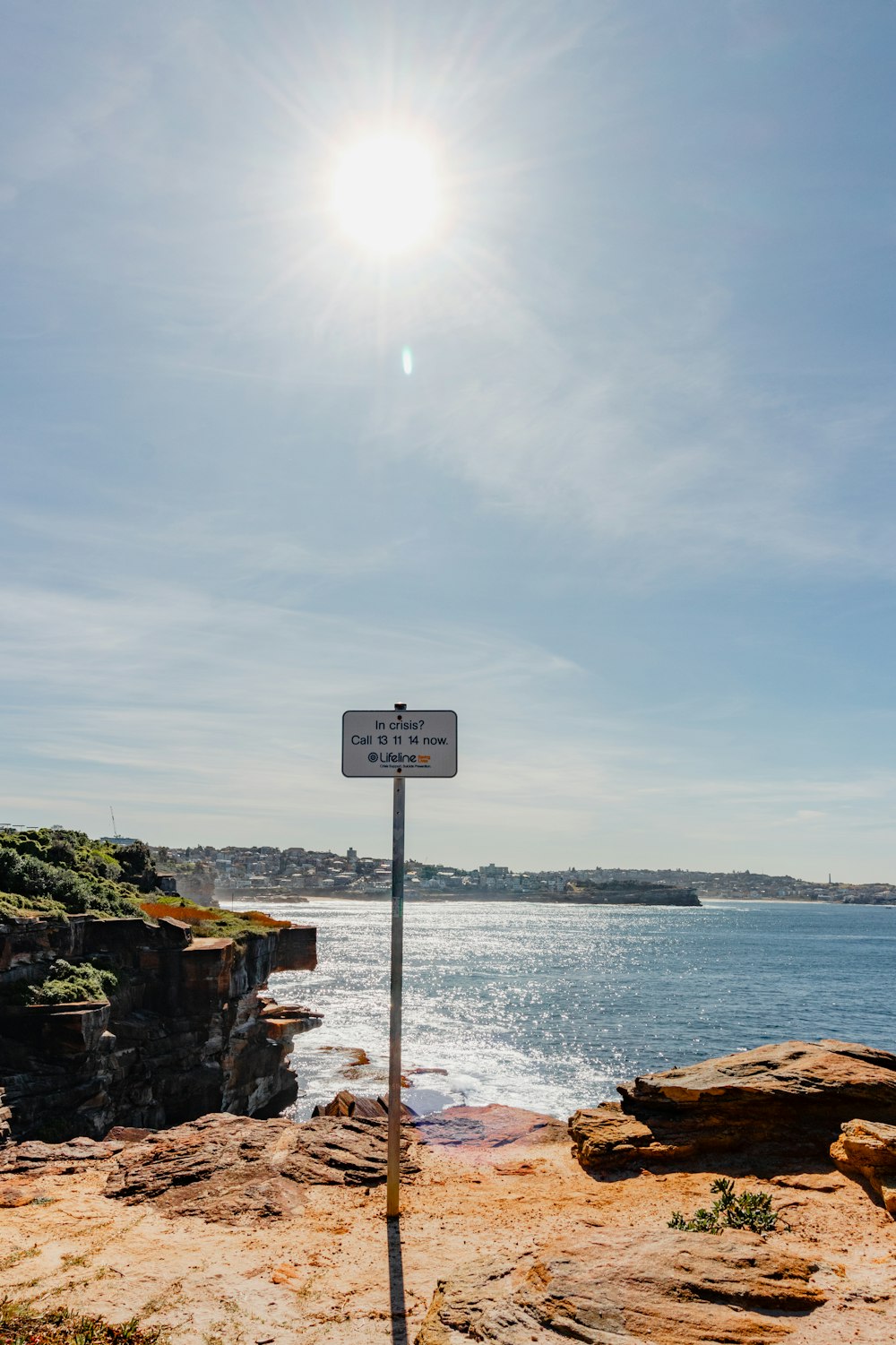 a street sign on the side of a cliff near the ocean