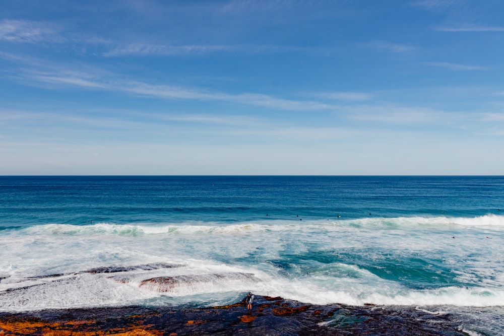 a large body of water sitting next to a rocky shore