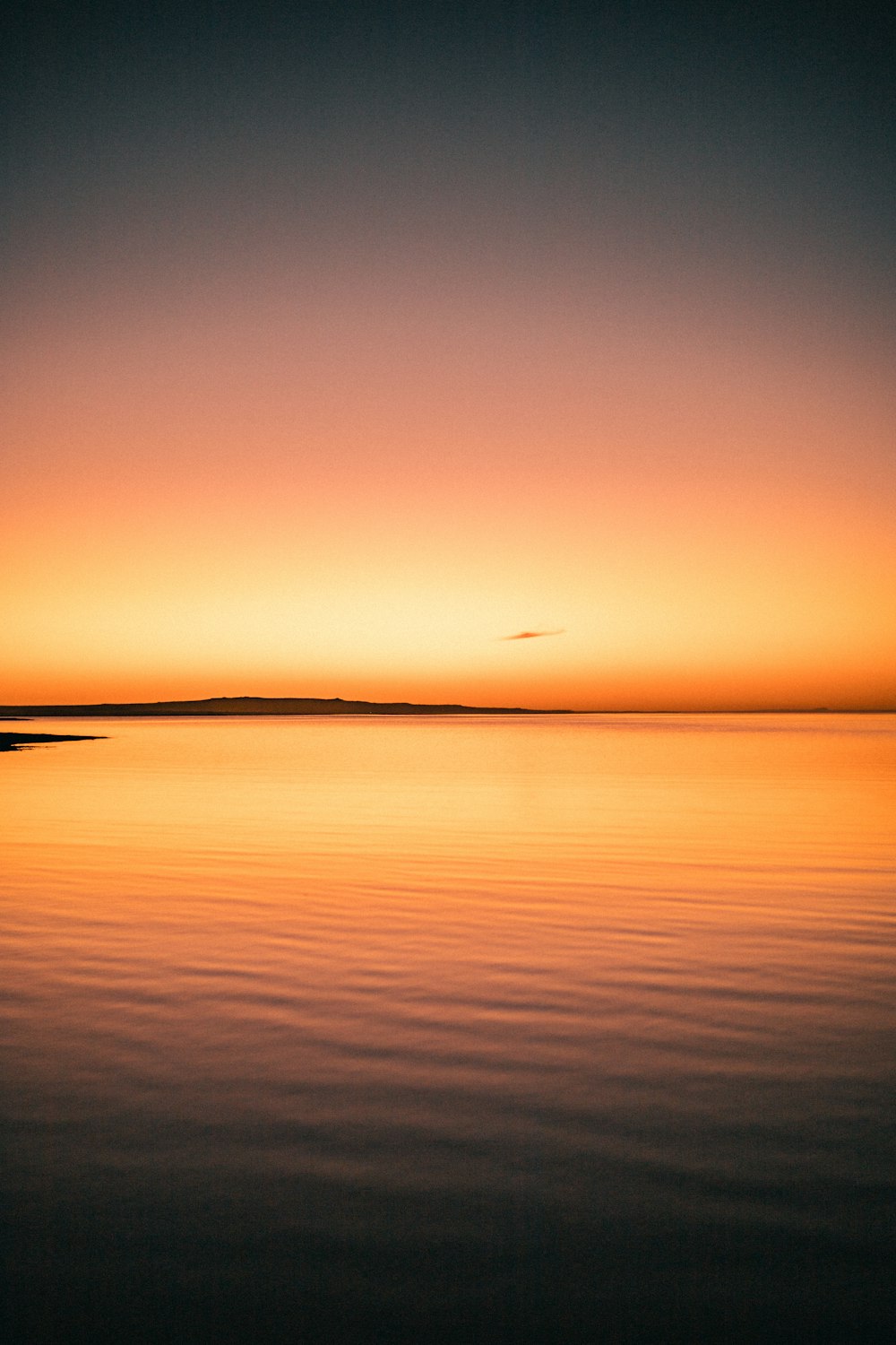 Le soleil se couche sur l’océan avec un bateau dans l’eau