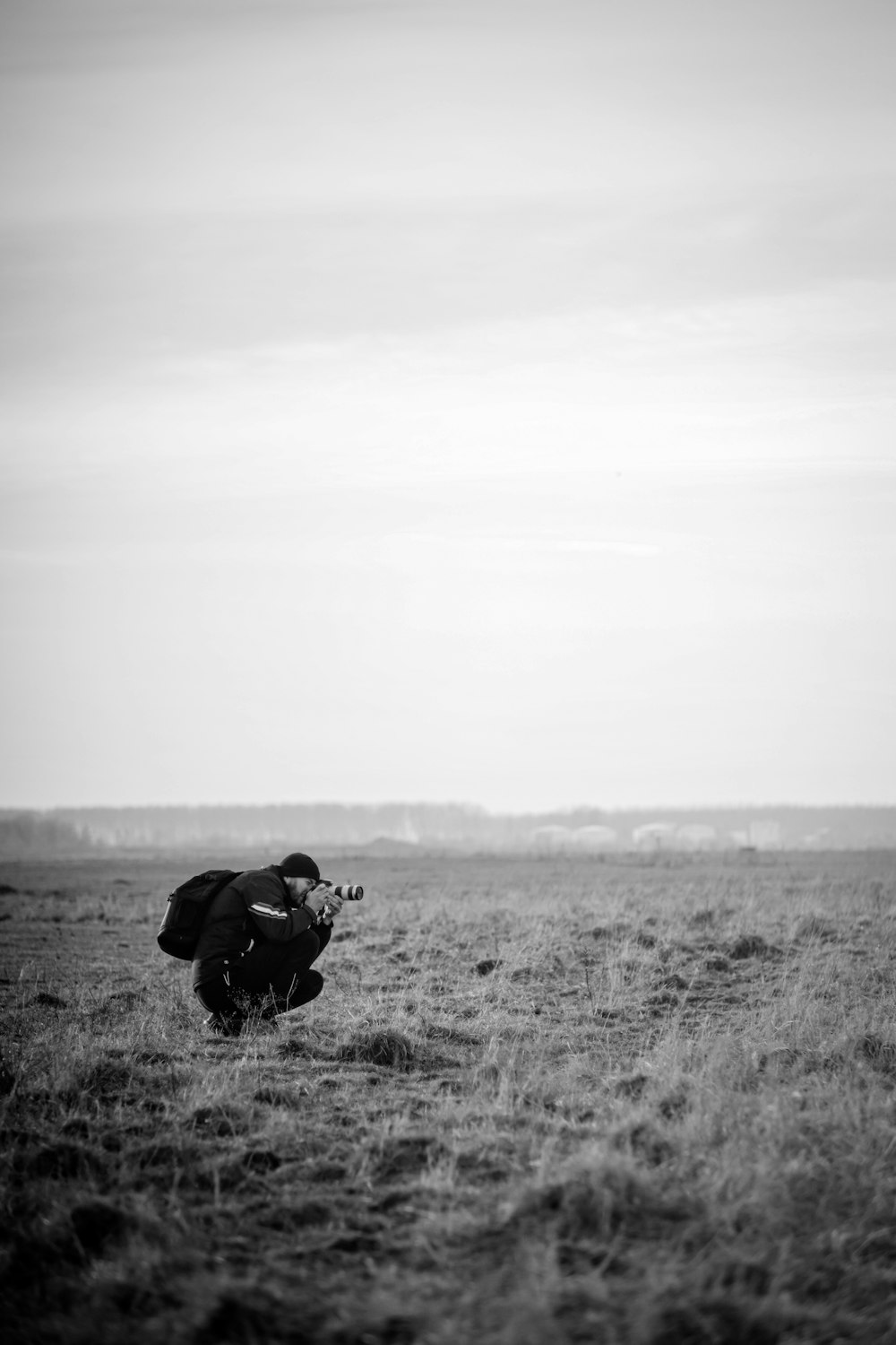 a black and white photo of a person kneeling in a field