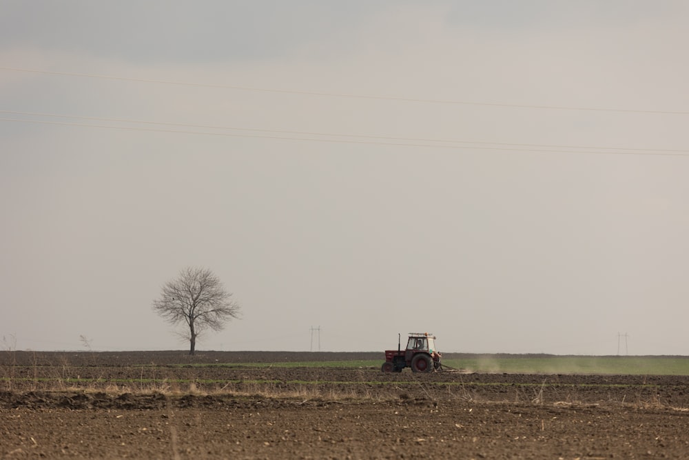 a tractor plowing a field on a cloudy day