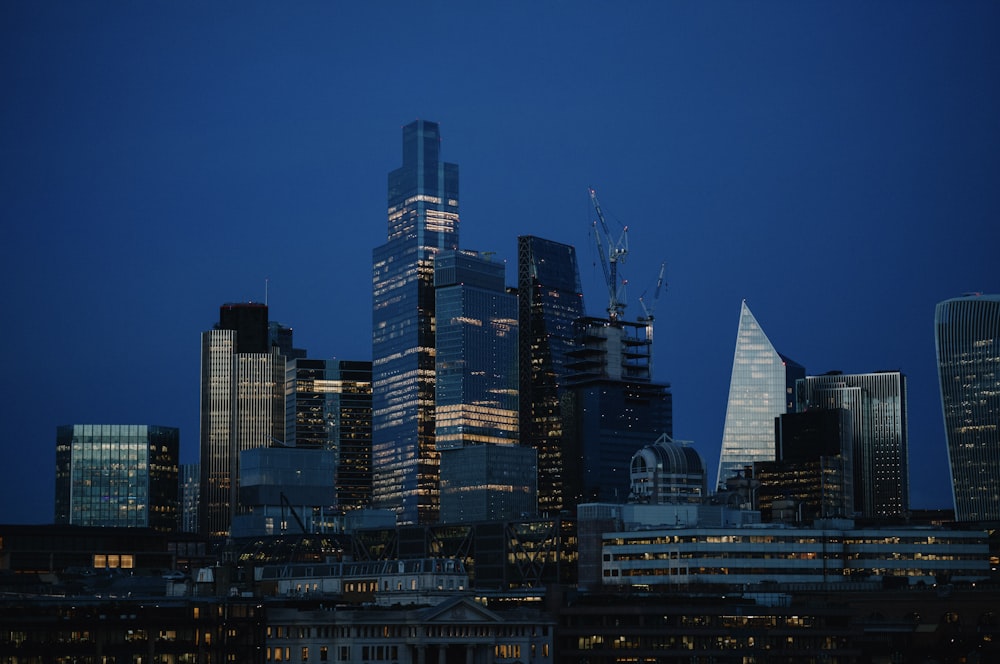 a city skyline with skyscrapers lit up at night