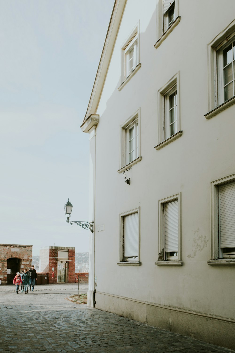 a group of people standing outside of a white building