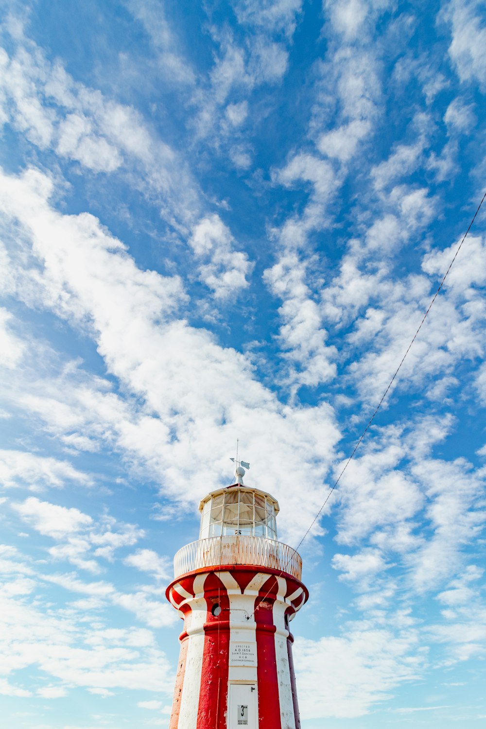 a red and white lighthouse under a blue sky