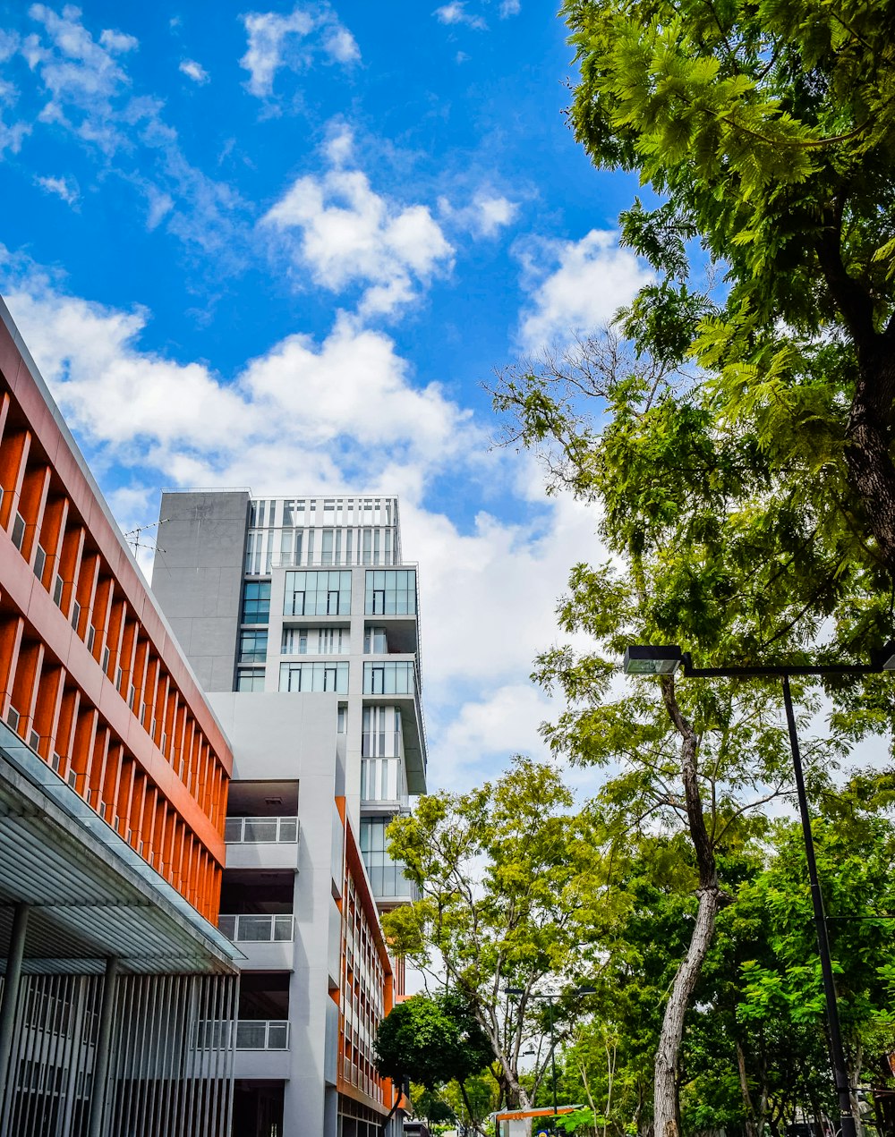 a tall building sitting next to a lush green forest