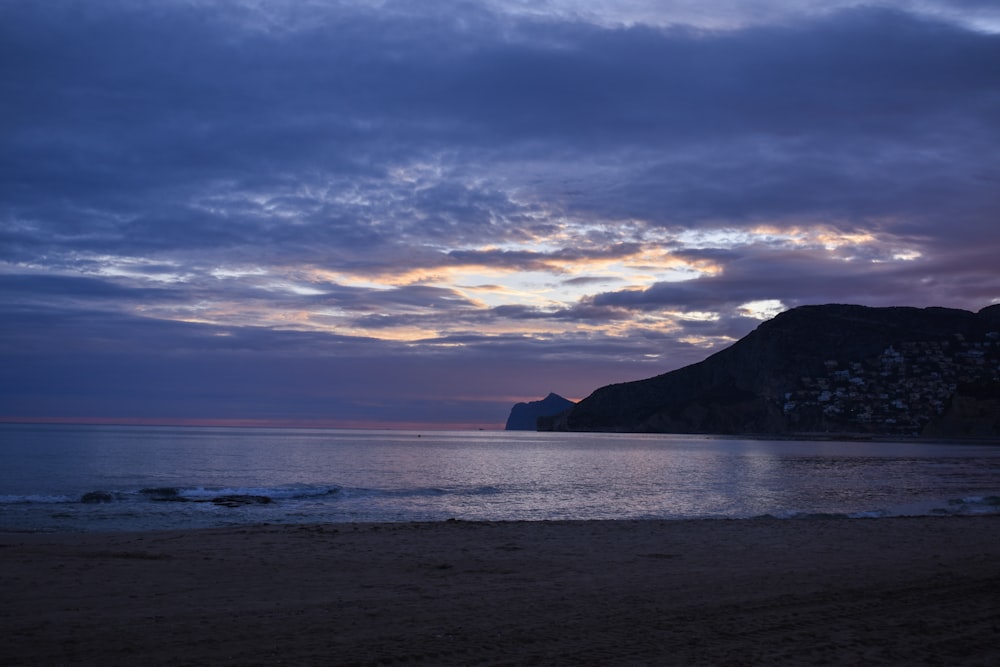 a beach with a mountain in the distance