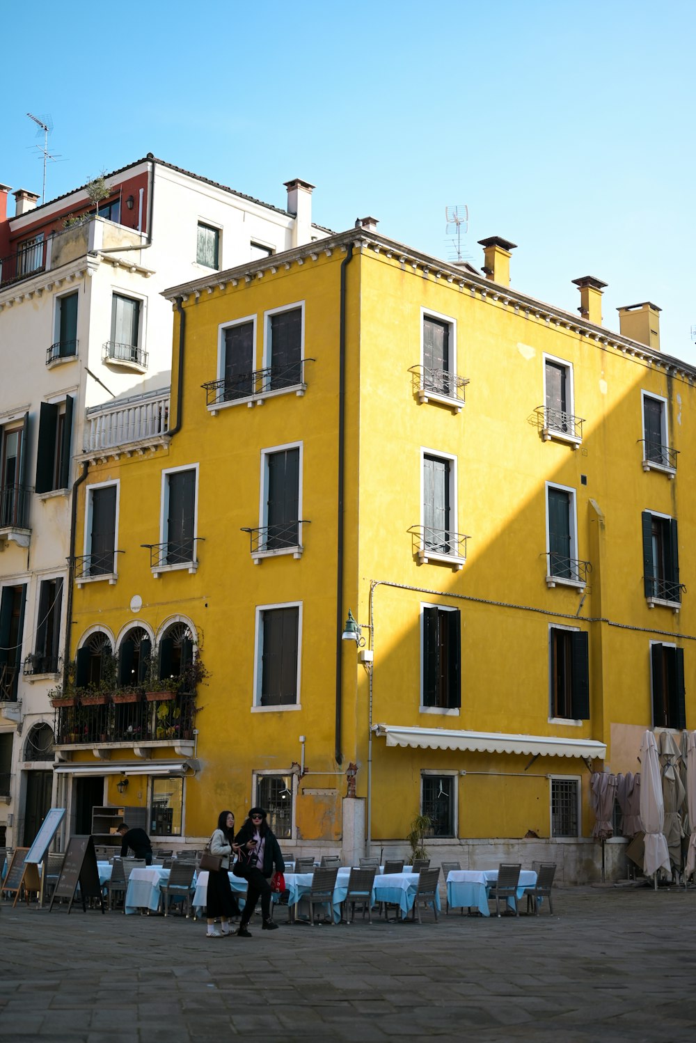 a group of people sitting outside of a yellow building