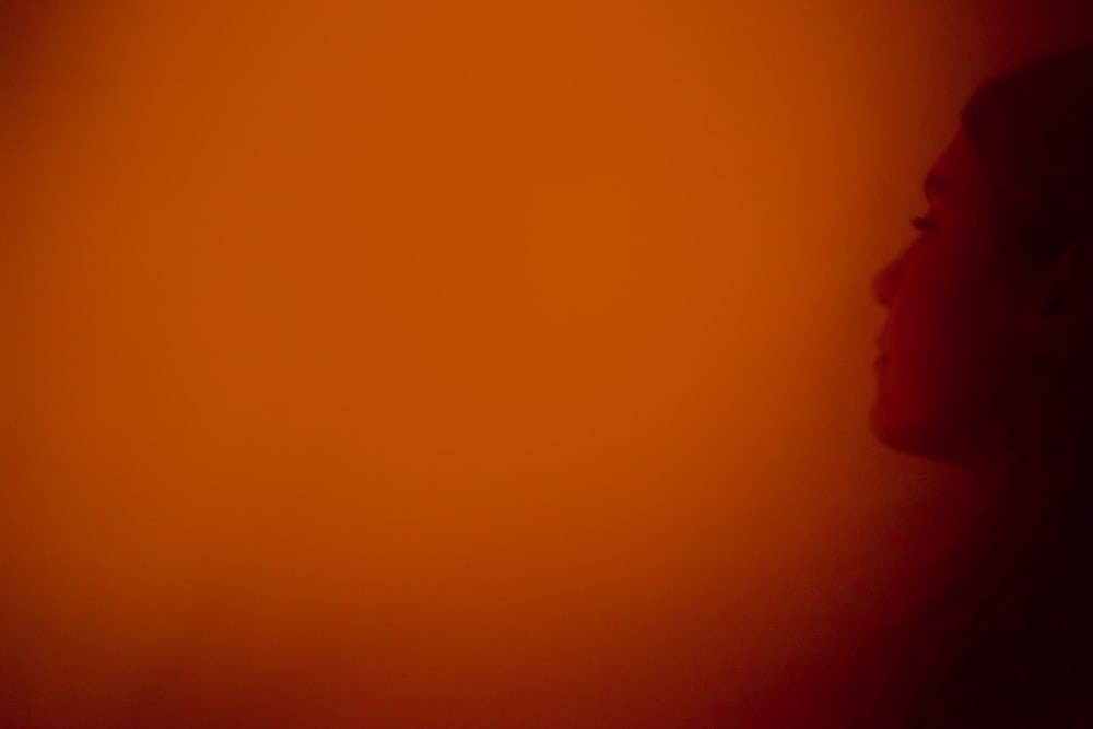 a woman's profile against a red background