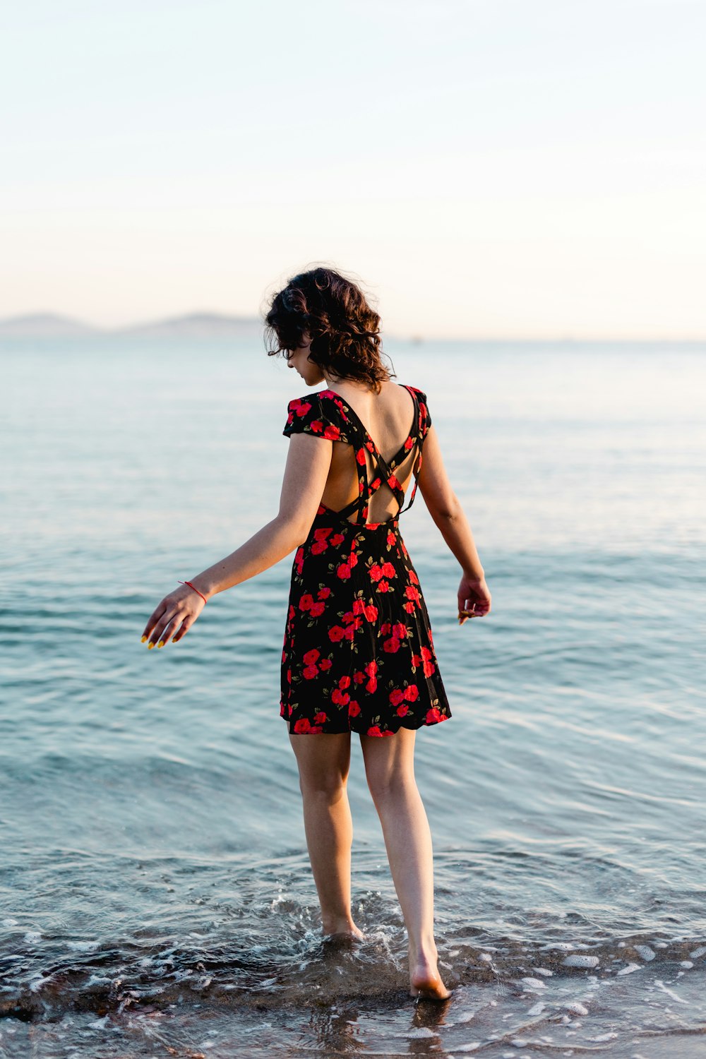 una mujer de pie en el agua en la playa