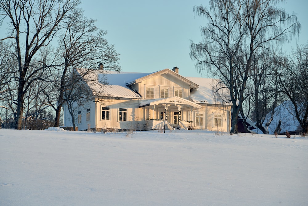 a white house in the middle of a snowy field