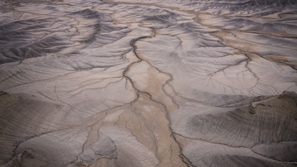 an aerial view of a desert landscape with mountains in the background