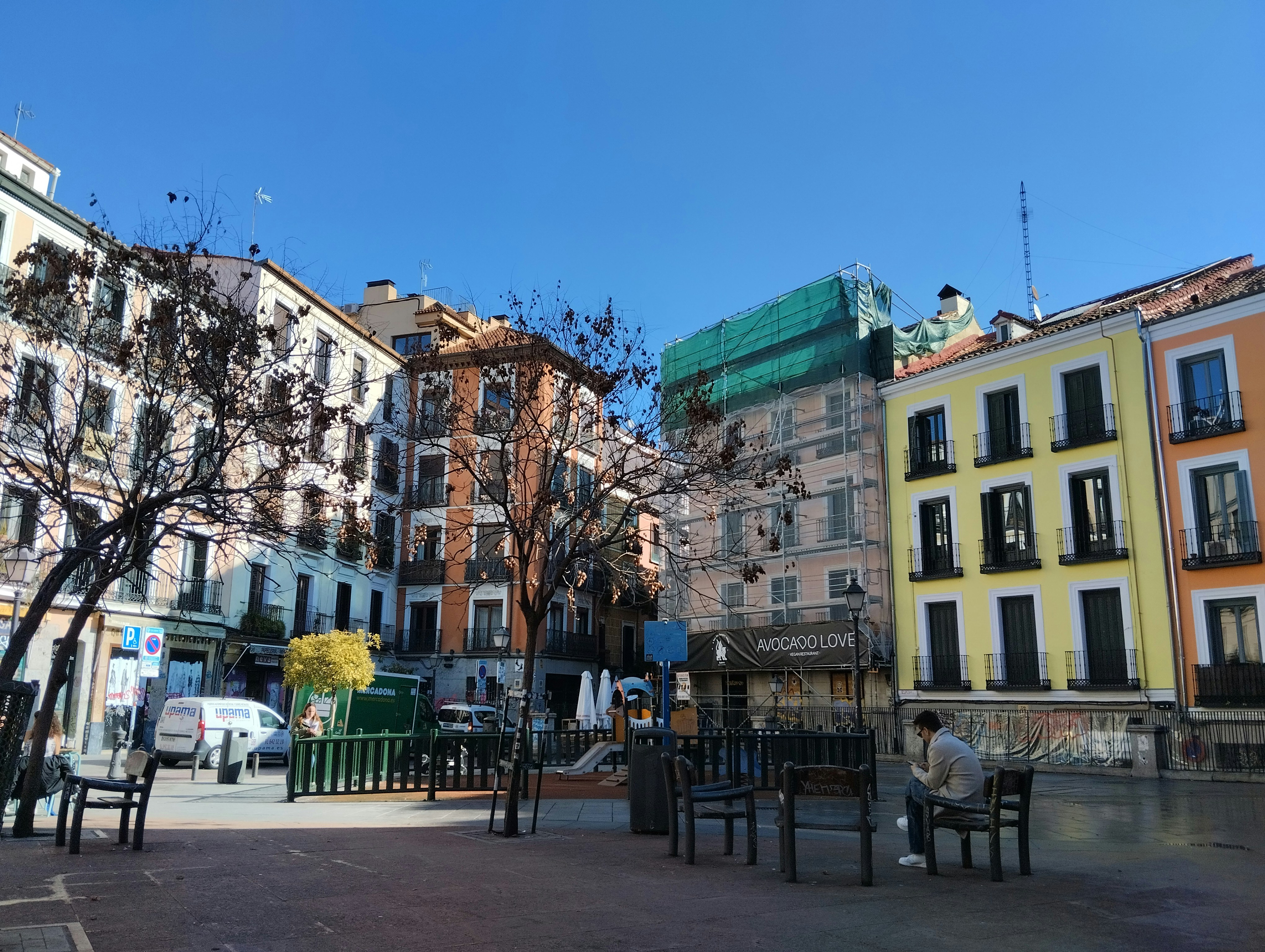 a person sitting on a bench in a city square