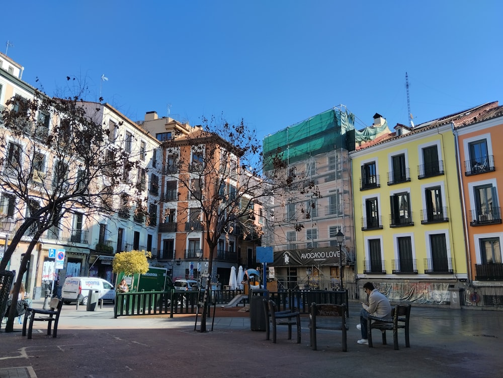 a person sitting on a bench in a city square