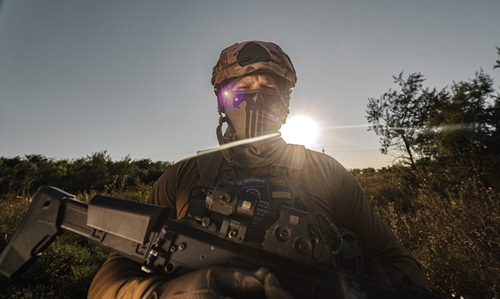 a man wearing a helmet and holding a machine gun