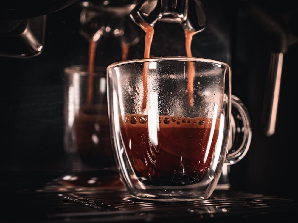 coffee being poured into a glass mug