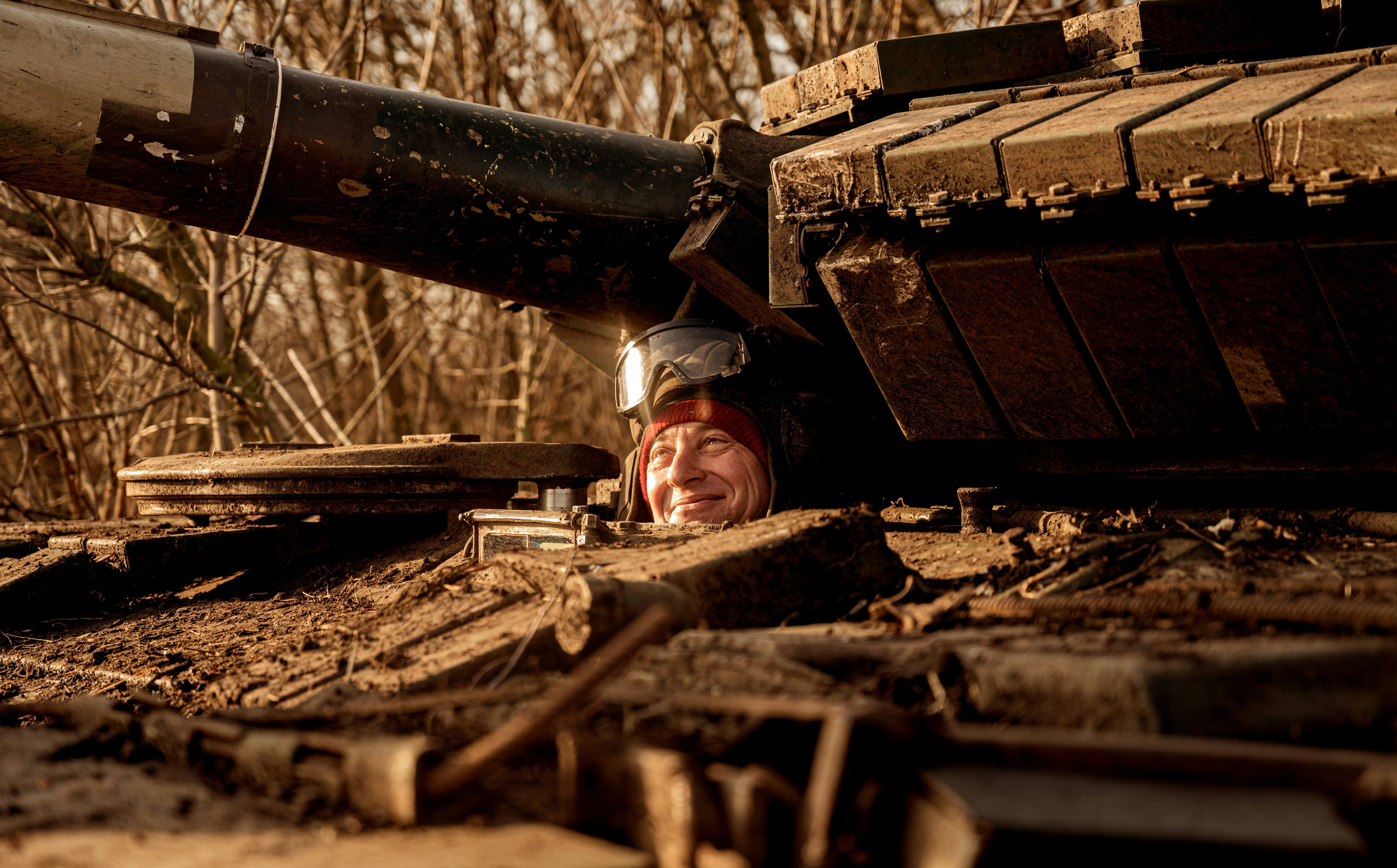 a man laying on the ground next to a tank