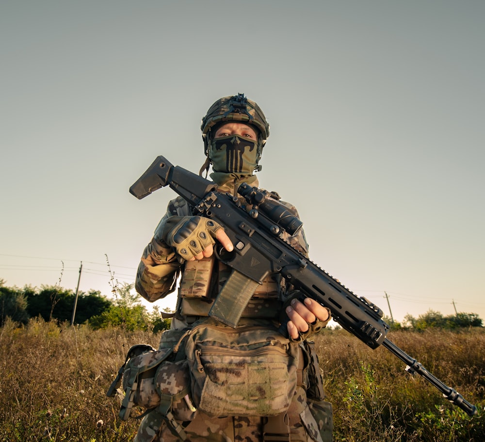 a man in camouflage holding a machine gun