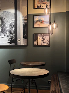 a table and chairs in a room with pictures on the wall