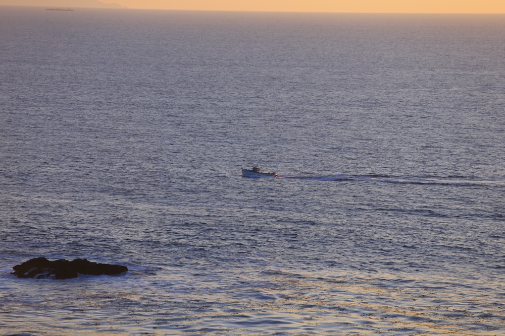 a small boat in the middle of the ocean