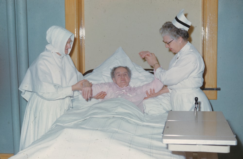 una donna in un letto d'ospedale assistita da un'infermiera