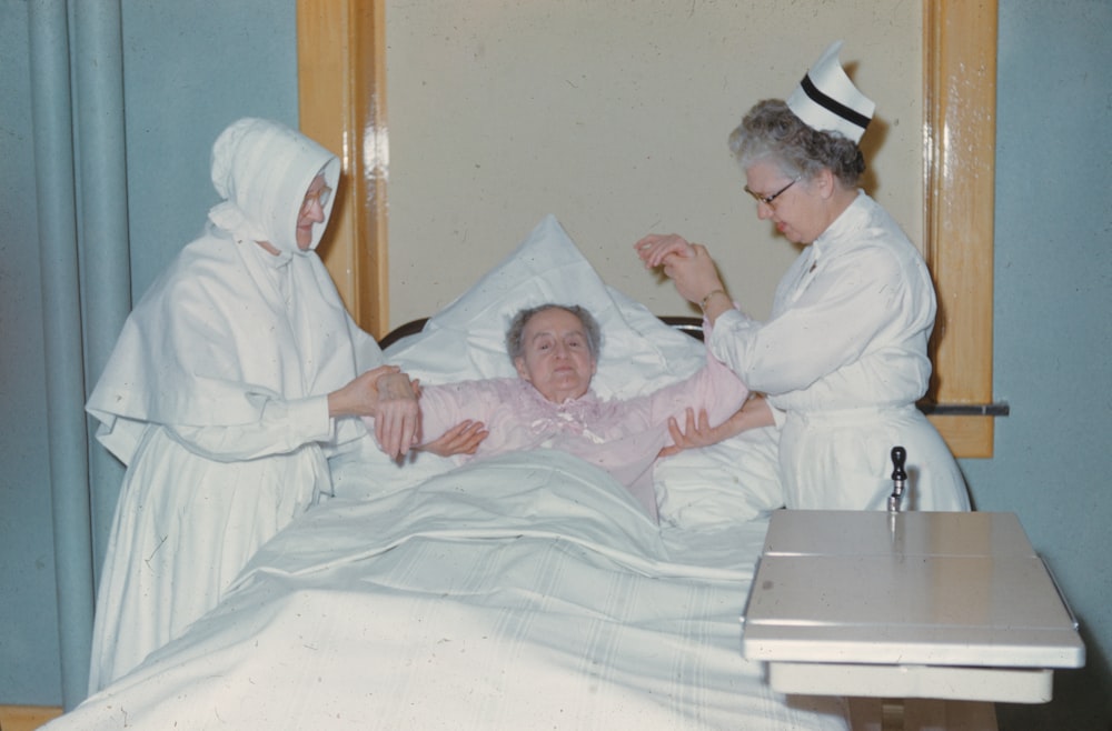 a woman in a hospital bed being assisted by a nurse