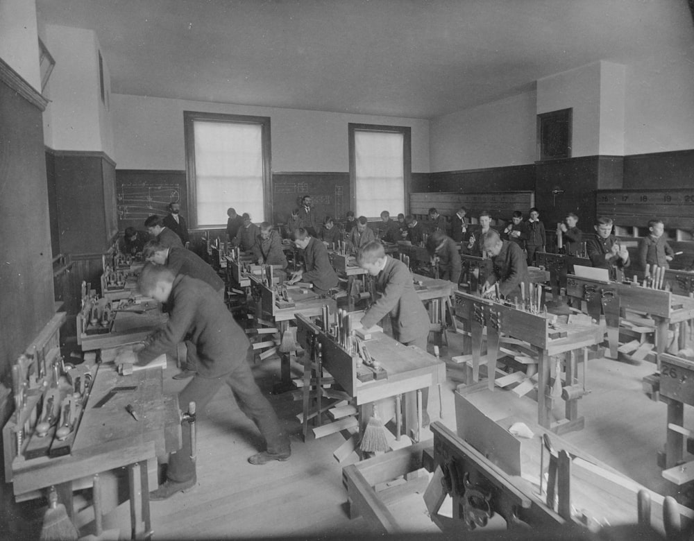 a black and white photo of men working in a factory