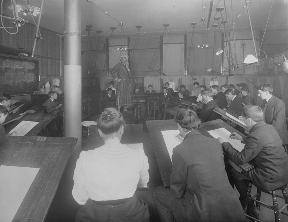 a group of men sitting at desks in a room