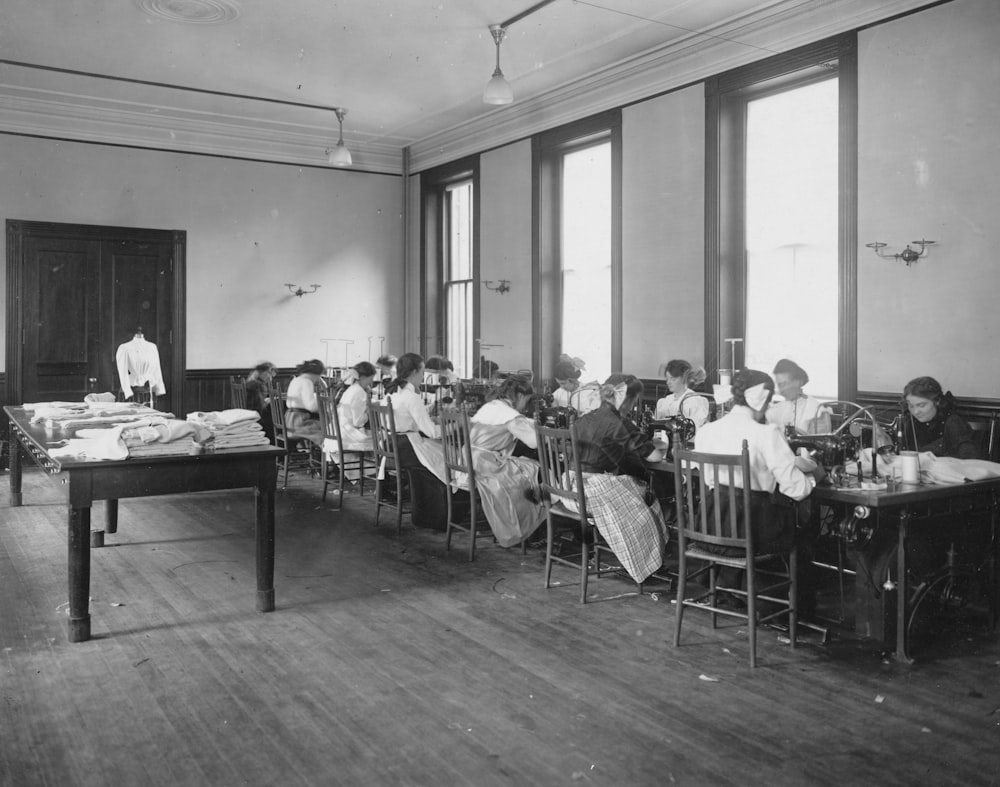 a group of people sitting at desks in a room