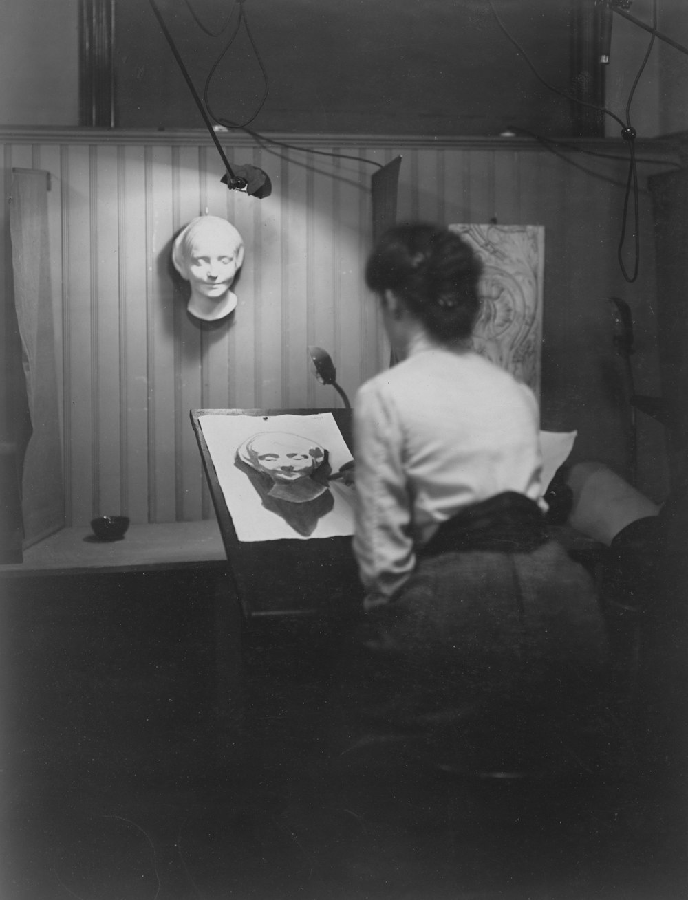 a black and white photo of a woman sitting at a desk