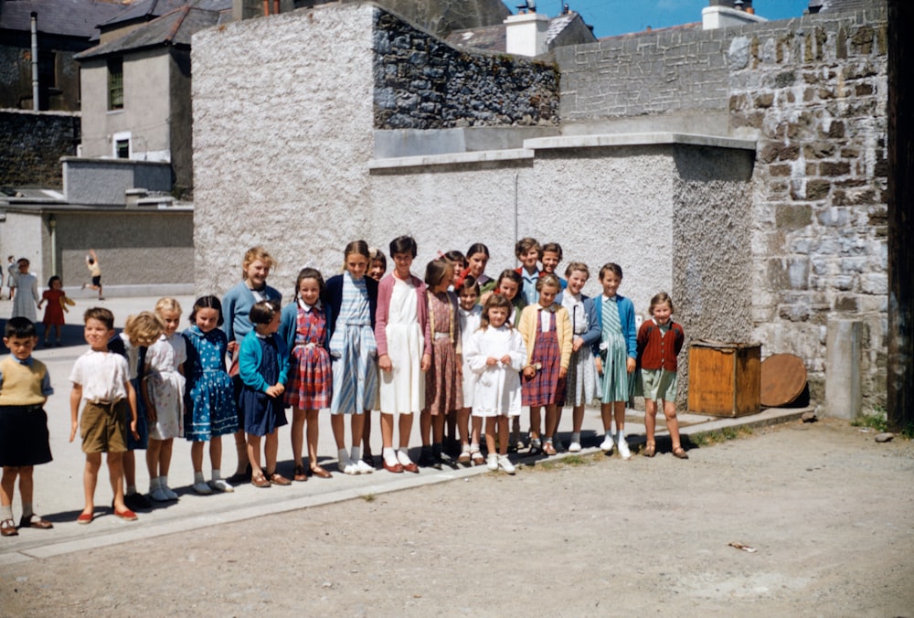 a group of children standing in front of a building
