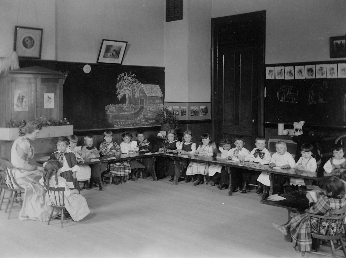 Children sitting at desks in a classroom, participating in character education activities.