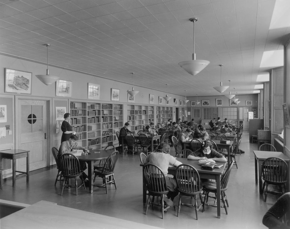 a black and white photo of people in a library