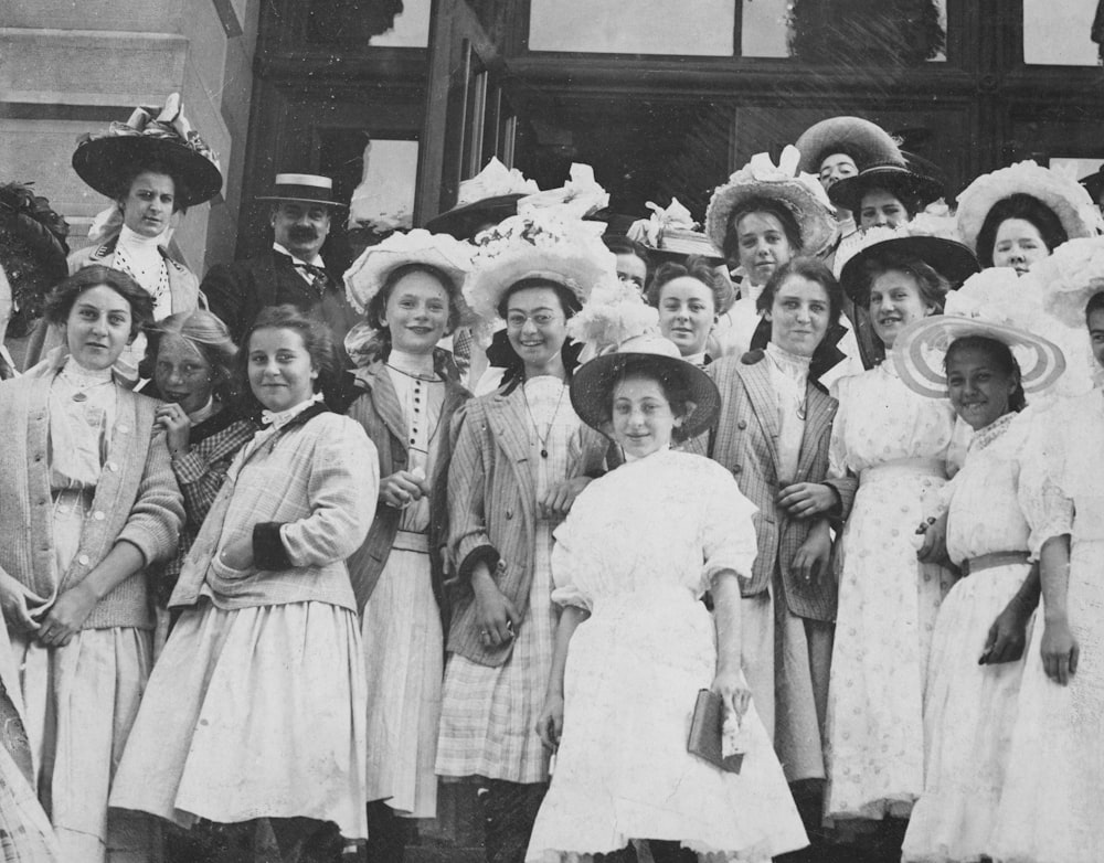 a group of women standing next to each other in front of a building