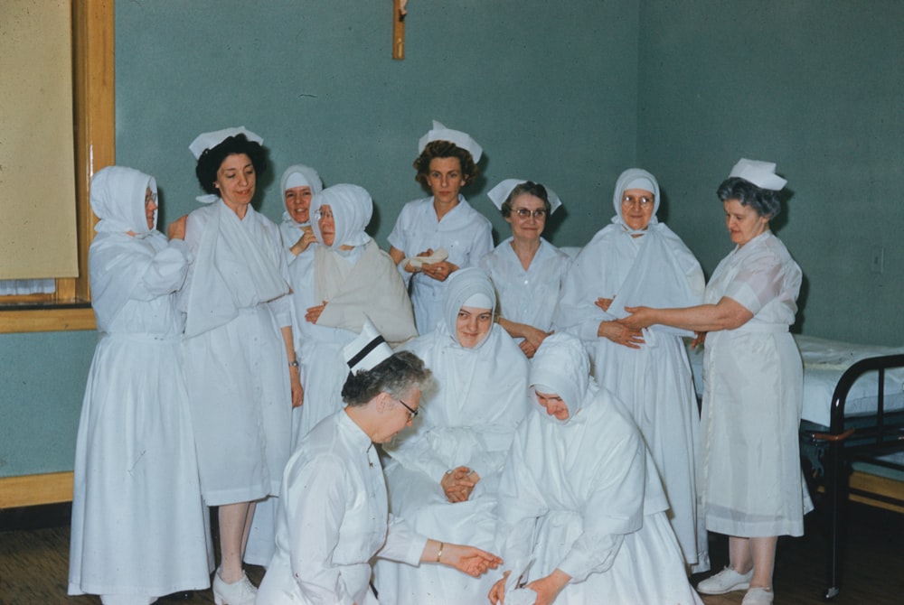 a group of women dressed in white in a room