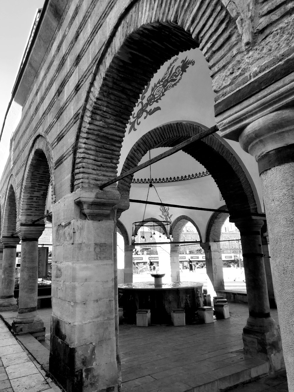a black and white photo of arches and benches
