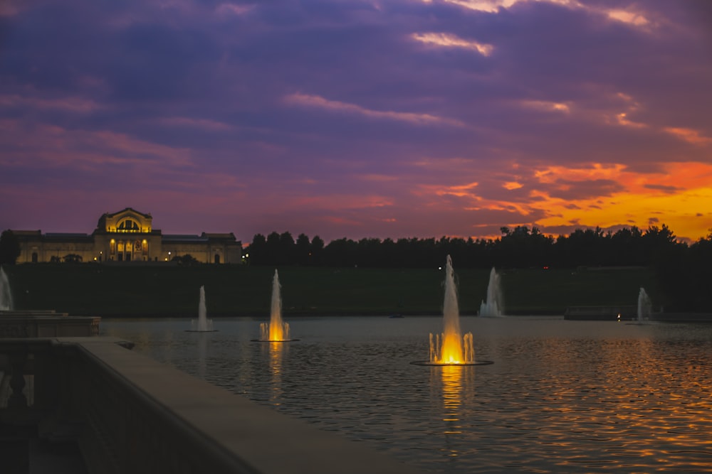 Una vista al atardecer de un edificio y una fuente