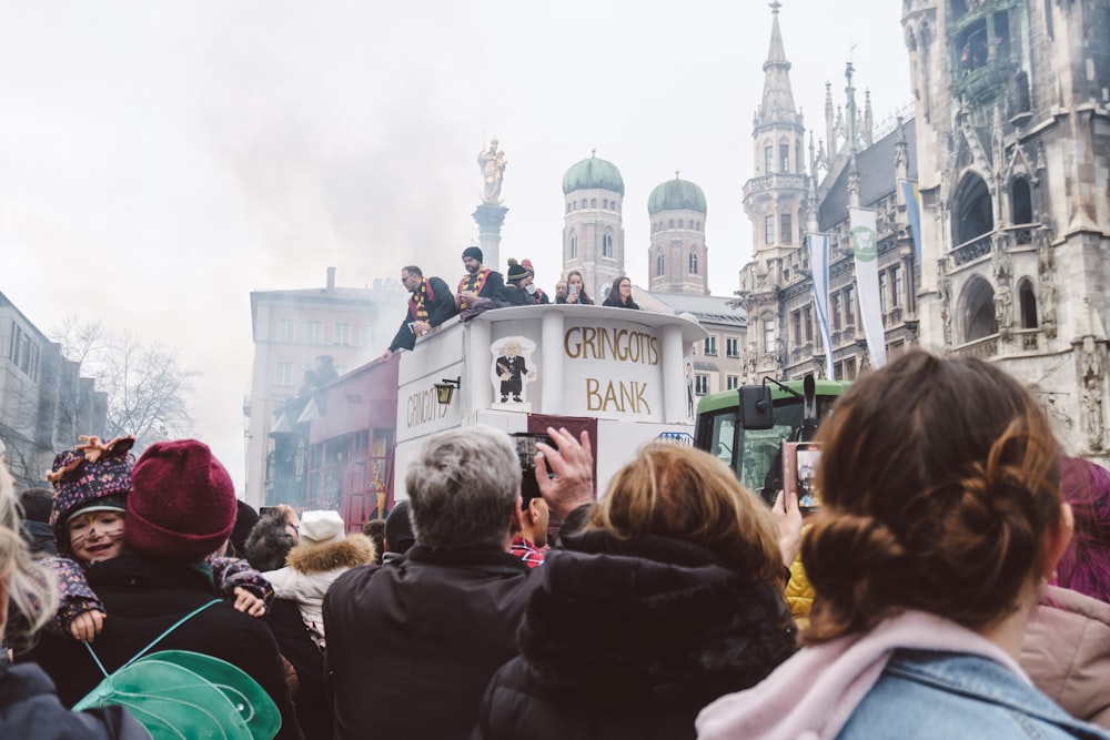 a crowd of people standing around a white bus