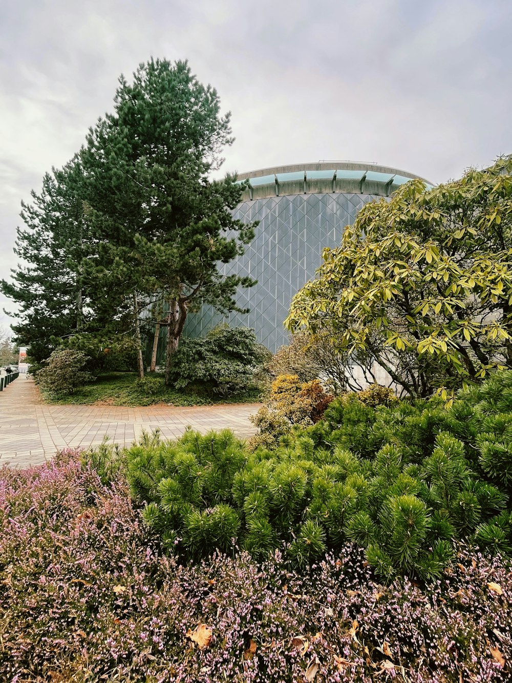 a circular building surrounded by trees and bushes