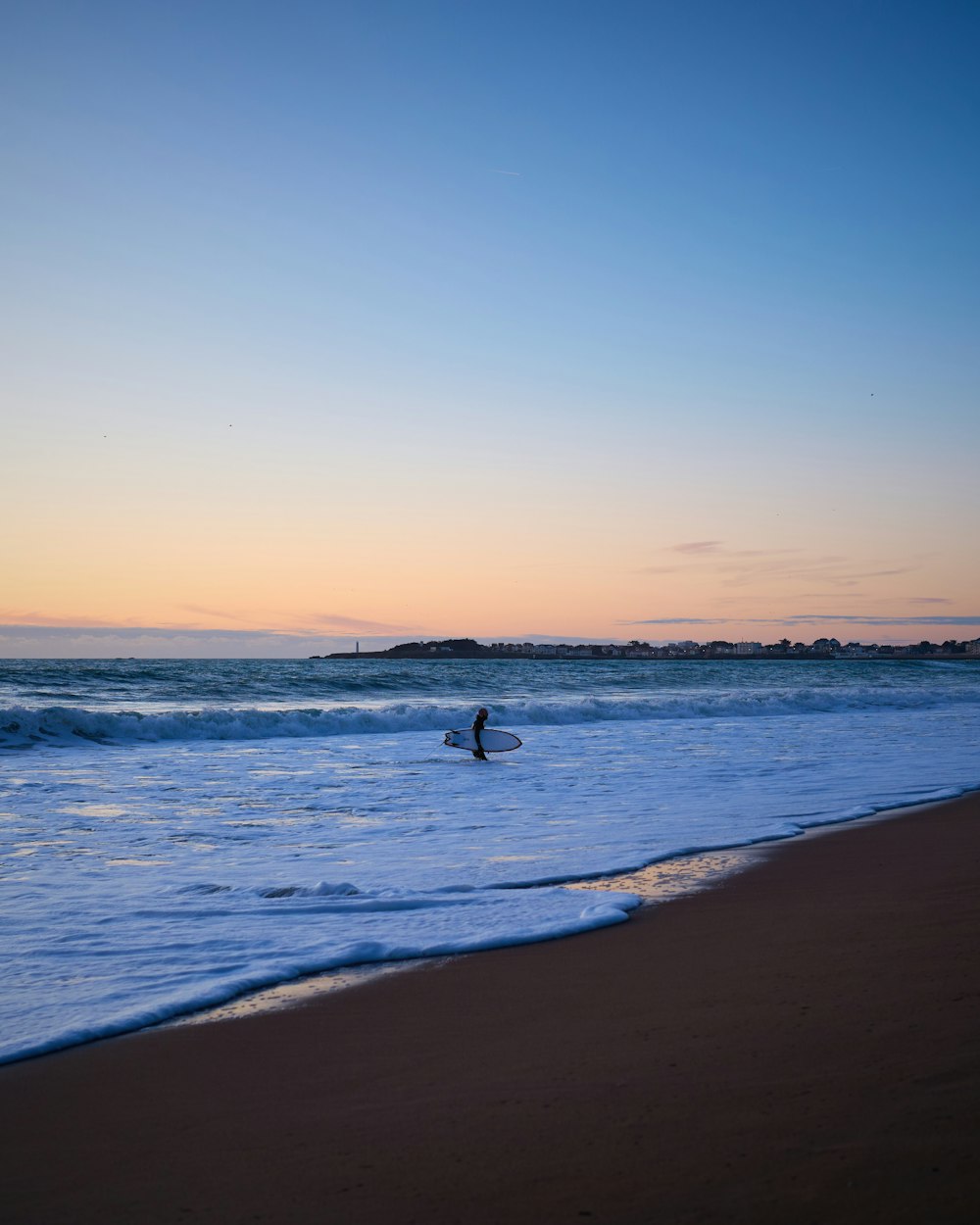 a person standing in the ocean with a surfboard