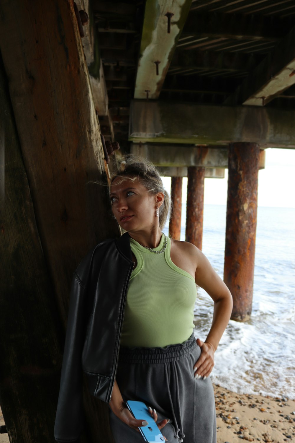 a woman standing next to a wooden pier