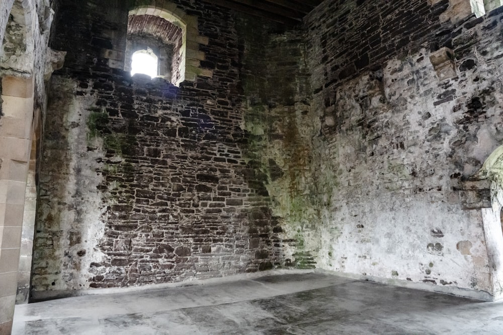 a room with a stone wall and a window