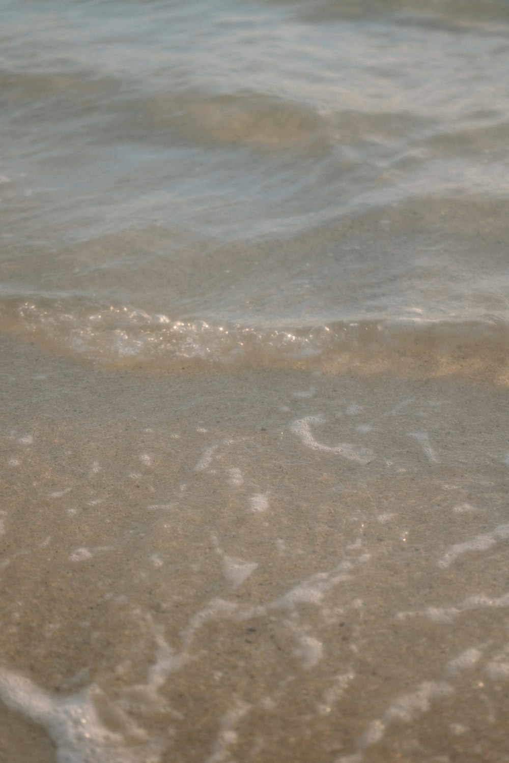 a close up of the sand and water at the beach