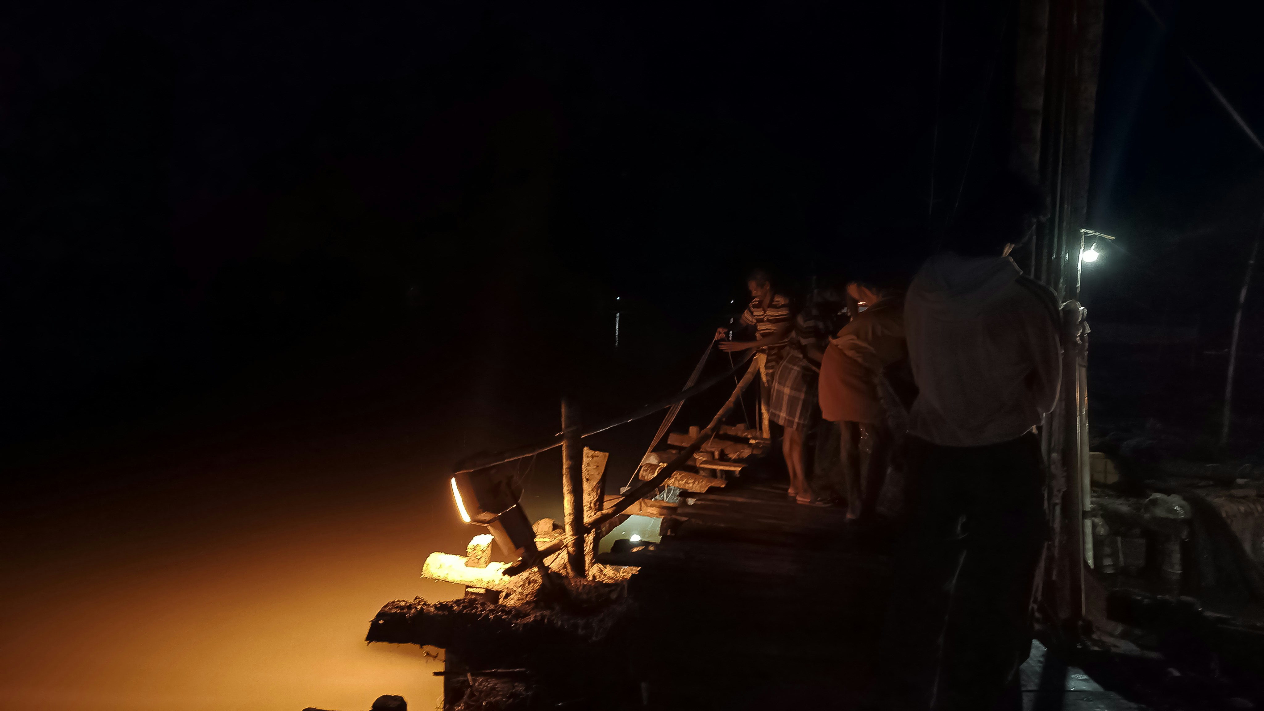 a group of people standing on a dock at night