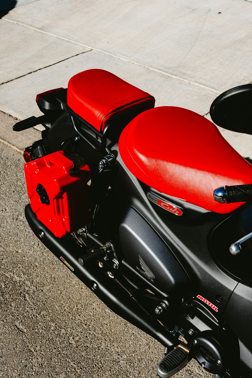 a red and black motorcycle parked on the street
