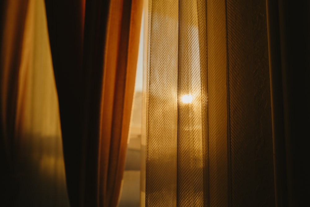 O sol brilha através das cortinas de uma janela