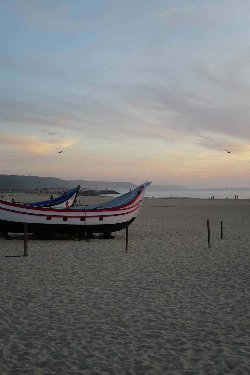 Un barco sentado en la parte superior de una playa de arena