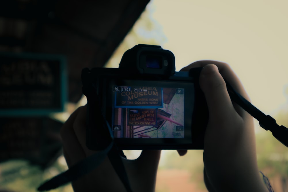 una persona che tiene in mano una macchina fotografica per scattare una foto