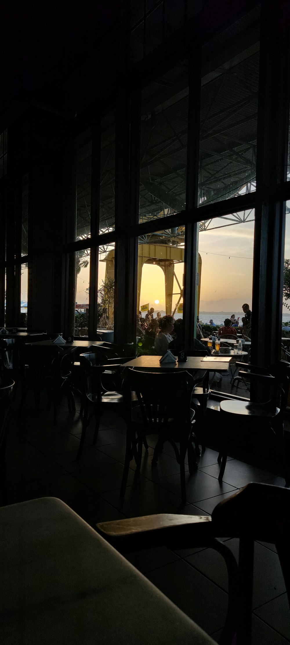 a restaurant with tables and chairs and a view of the ocean