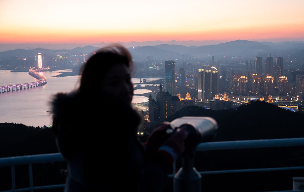 a woman looking out over a city at night