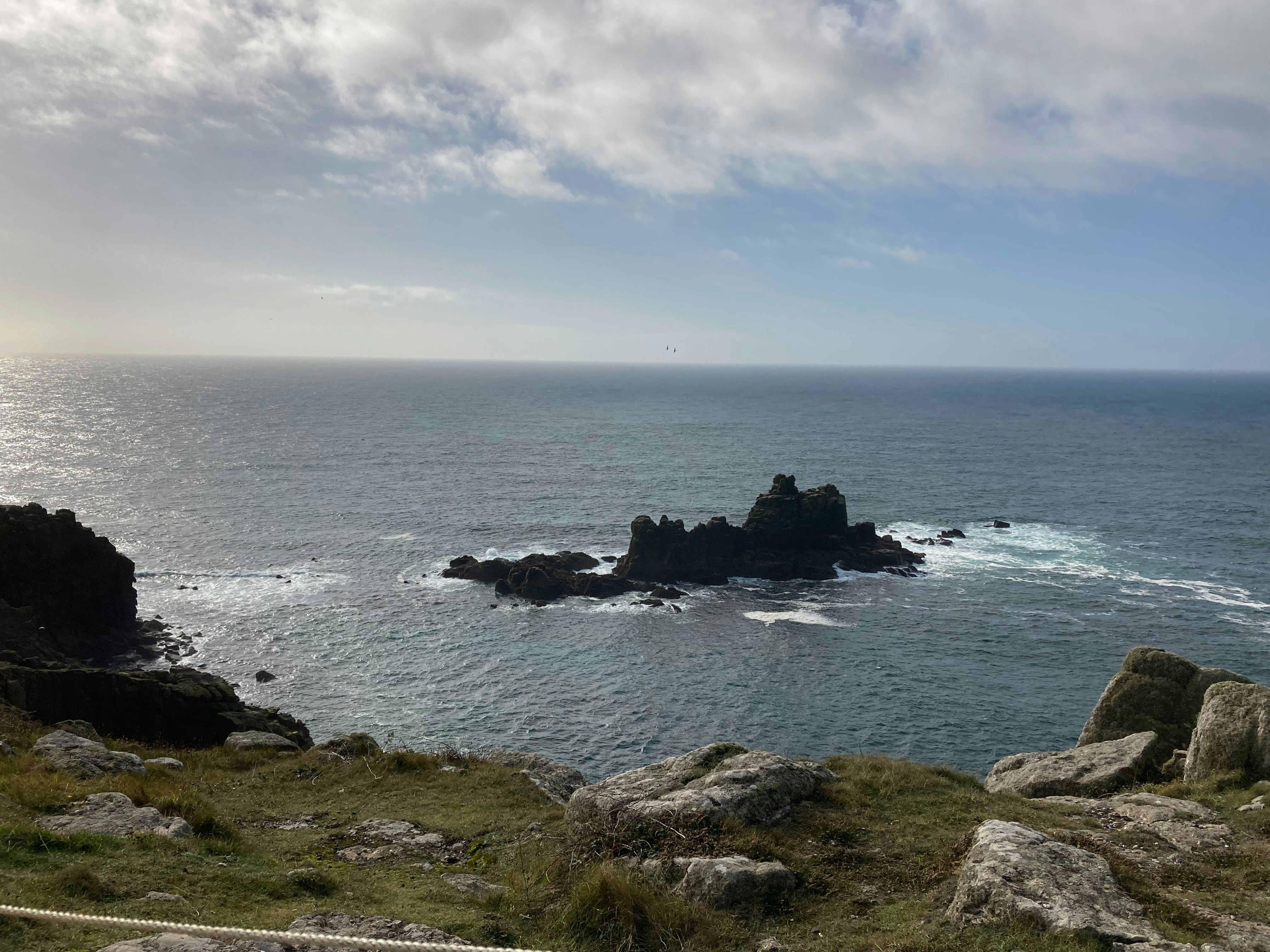 ein Gewässer, das von Felsen und Gras umgeben ist